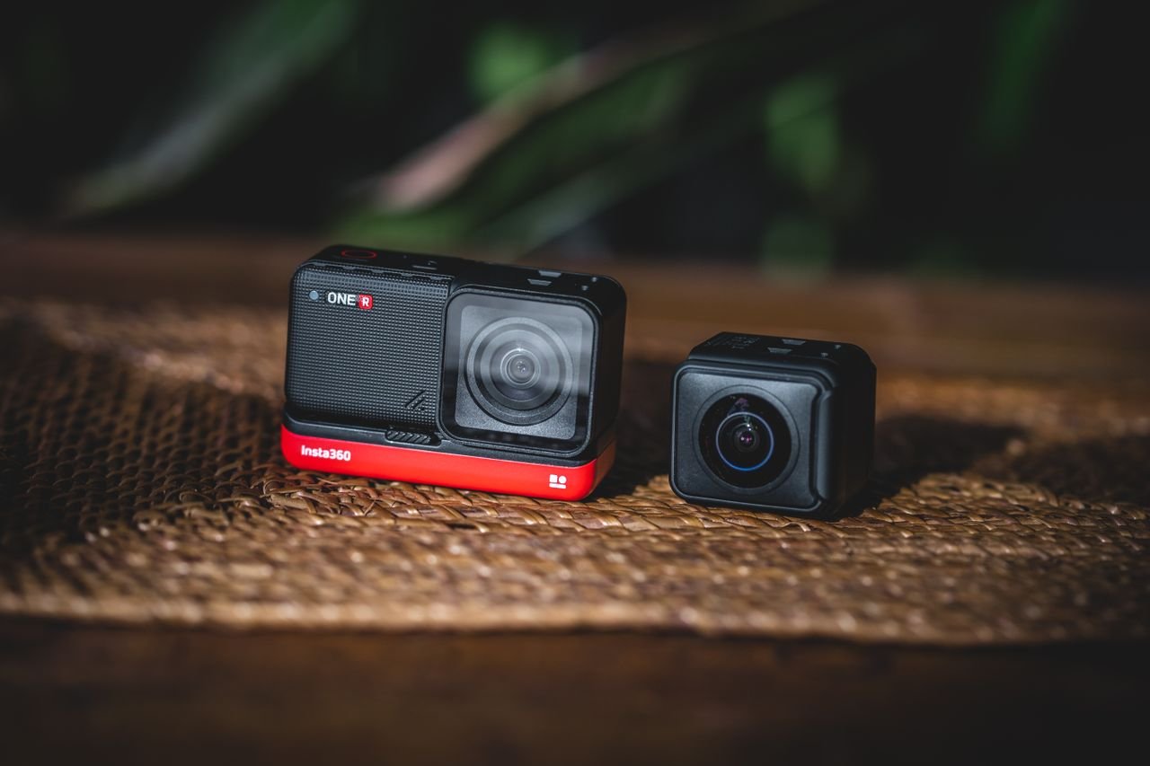 Two modular action cameras resting on a wooden table, ideal for tech enthusiasts and content creators.