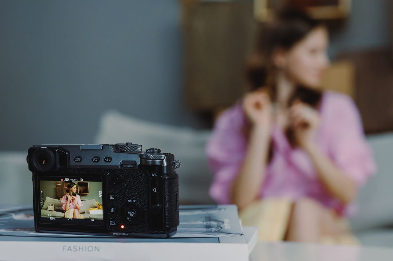 Close-up of a DSLR photographing a woman in a stylish setting.